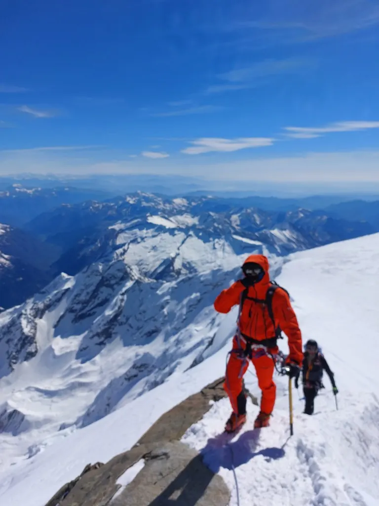 Climber on a snowy summit ridge