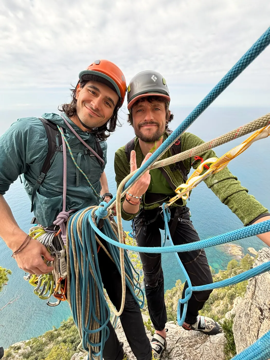 Two climbers at a belay above the sea