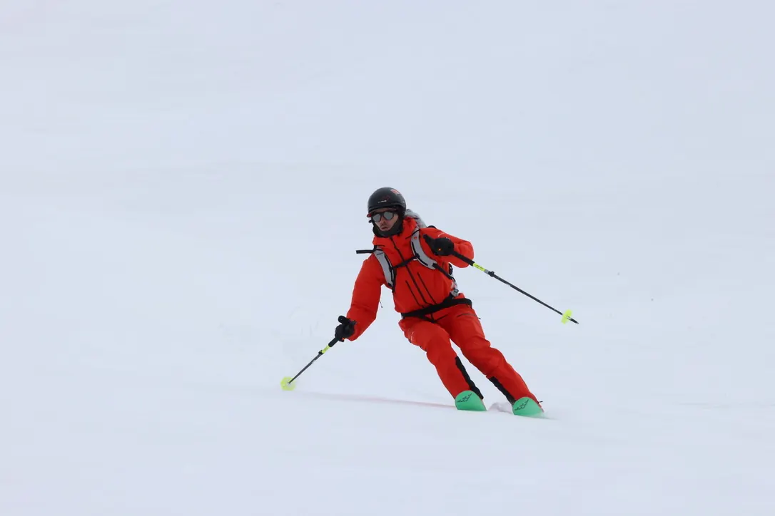 Skier carving a turn on an open snow slope